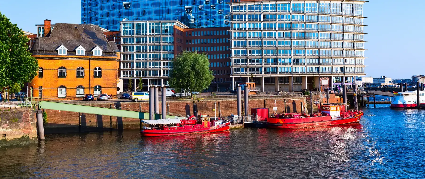 Hamburger Hafenrand mit Backsteinspeichern, Booten und den Neubauten der Hafencity
